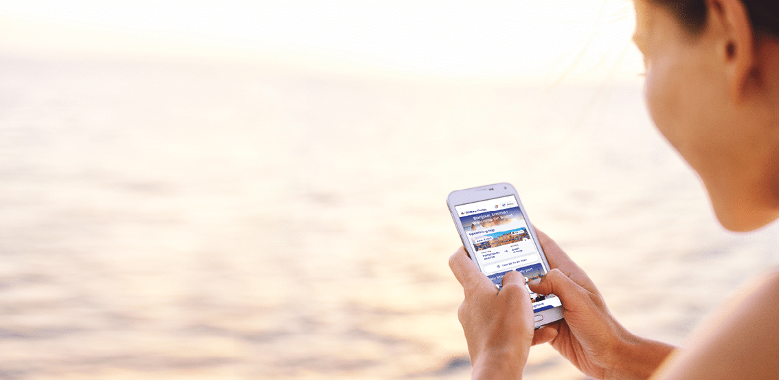 Smartphone woman texting on social media app looking at display screen for sms reading on ocean background on a sea cruise balcony or beach at sunset on holiday. Unrecognizable girl using smart phone.