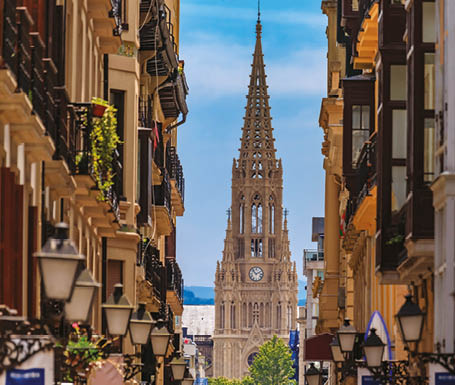 View along a street in old town onto Good Shepherd of San Sebastian cathedral in Gothic Revival with a 75 m spire in Donostia, Basque Country, Spain